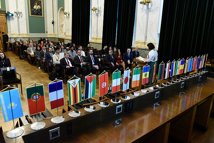 Uczestnicy siedżacy w dużej zabytkowej sali