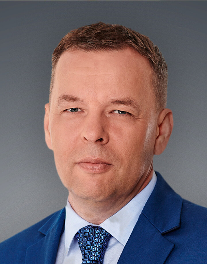 Mężczyzna w średnim wieku w granatowym garniturze.