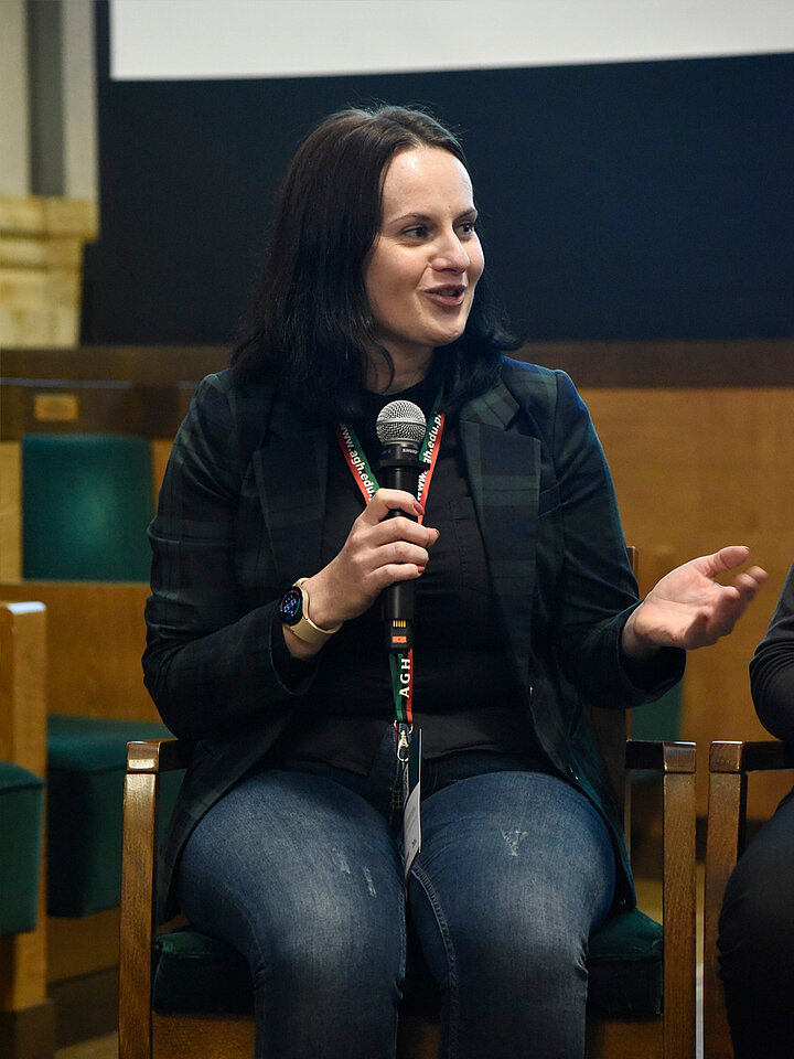 Siedząca kobieta mówi do mikrofonu