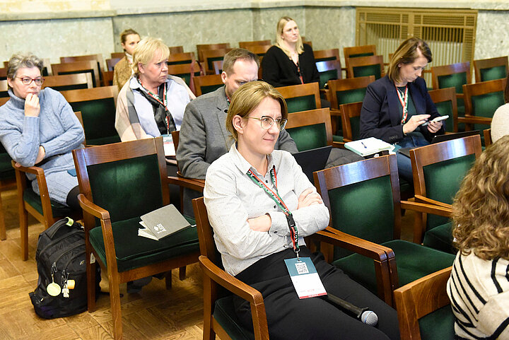 Uczestnicy siedżcy w sali.