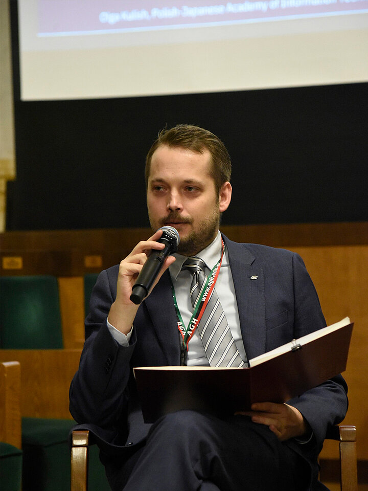 Siedzący mężczyzna mówi do mikrofonu